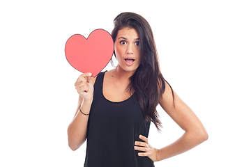 Image showing beautiful happy brunette woman holding and showing a big red hea