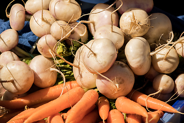 Image showing bunches of carrots and fresh turnips on a market stall