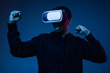 Image showing Young african-american man\'s using VR-glasses in neon light