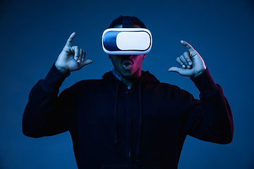 Image showing Young african-american man\'s using VR-glasses in neon light