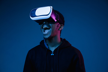 Image showing Young african-american man\'s using VR-glasses in neon light