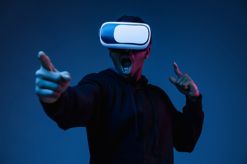 Image showing Young african-american man\'s using VR-glasses in neon light