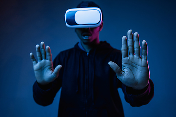 Image showing Young african-american man\'s using VR-glasses in neon light