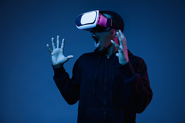 Image showing Young african-american man\'s using VR-glasses in neon light