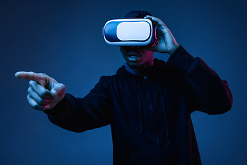 Image showing Young african-american man\'s using VR-glasses in neon light