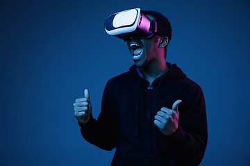 Image showing Young african-american man\'s using VR-glasses in neon light