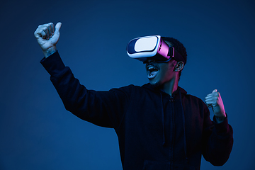 Image showing Young african-american man\'s using VR-glasses in neon light