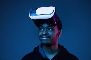 Image showing Young african-american man\'s using VR-glasses in neon light