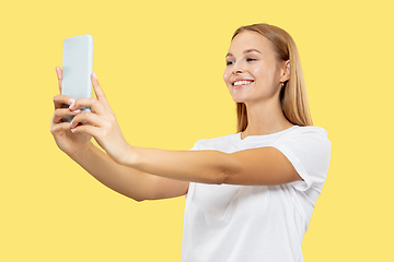 Image showing Caucasian young woman\'s half-length portrait on yellow background