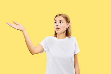 Image showing Caucasian young woman\'s half-length portrait on yellow background