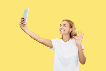 Image showing Caucasian young woman\'s half-length portrait on yellow background