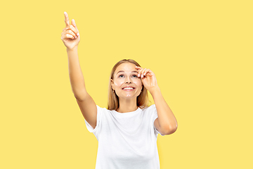 Image showing Caucasian young woman\'s half-length portrait on yellow background