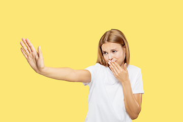 Image showing Caucasian young woman\'s half-length portrait on yellow background