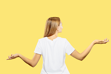 Image showing Caucasian young woman\'s half-length portrait on yellow background