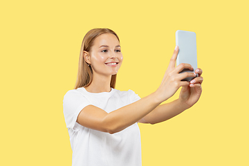 Image showing Caucasian young woman\'s half-length portrait on yellow background