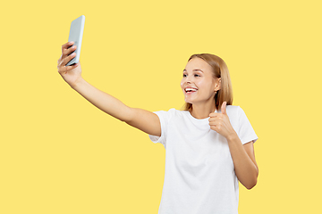 Image showing Caucasian young woman\'s half-length portrait on yellow background