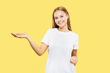 Image showing Caucasian young woman\'s half-length portrait on yellow background