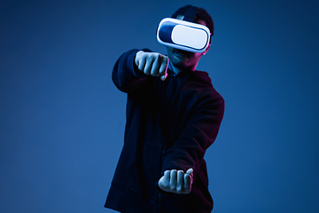 Image showing Young african-american man\'s using VR-glasses in neon light