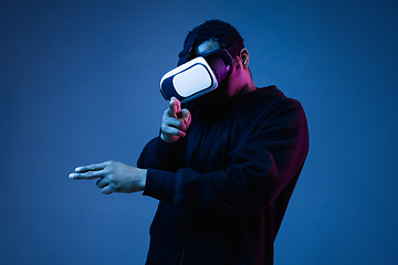 Image showing Young african-american man\'s using VR-glasses in neon light