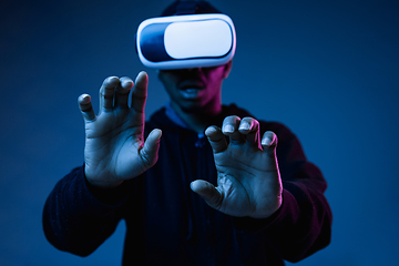 Image showing Young african-american man\'s using VR-glasses in neon light