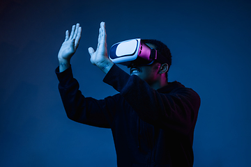 Image showing Young african-american man\'s using VR-glasses in neon light