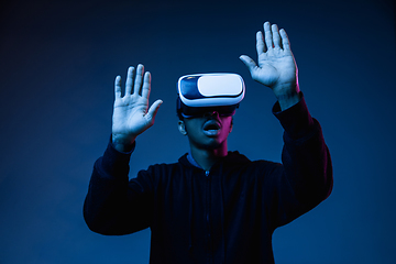 Image showing Young african-american man\'s using VR-glasses in neon light