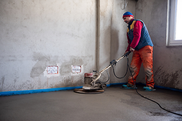 Image showing worker performing and polishing sand and cement screed floor