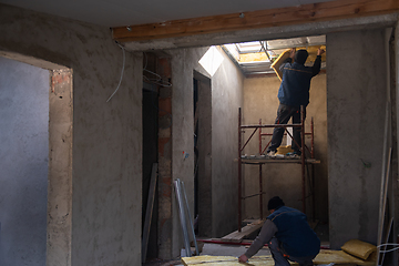 Image showing roofer man installing thermal insulation layer