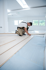 Image showing Worker Installing New Laminated Wooden Floor