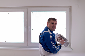 Image showing construction worker plastering on gypsum walls