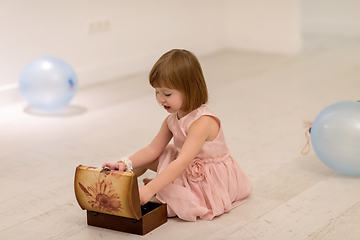 Image showing little girl enjoying while playing with mother\'s jewelry