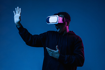 Image showing Young african-american man\'s using VR-glasses in neon light