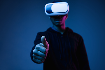 Image showing Young african-american man\'s using VR-glasses in neon light