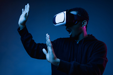 Image showing Young african-american man\'s using VR-glasses in neon light