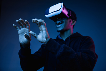 Image showing Young african-american man\'s using VR-glasses in neon light