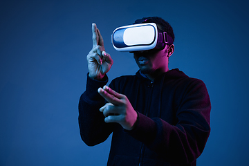 Image showing Young african-american man\'s using VR-glasses in neon light