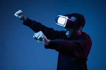 Image showing Young african-american man\'s using VR-glasses in neon light