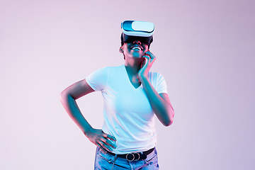 Image showing Young african-american woman\'s using VR-glasses in neon light