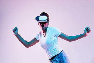 Image showing Young african-american woman\'s using VR-glasses in neon light