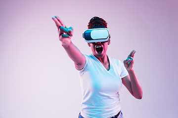 Image showing Young african-american woman\'s using VR-glasses in neon light