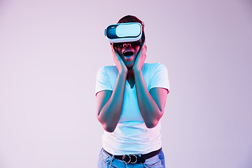 Image showing Young african-american woman\'s using VR-glasses in neon light