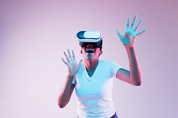 Image showing Young african-american woman\'s using VR-glasses in neon light