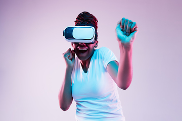 Image showing Young african-american woman\'s using VR-glasses in neon light