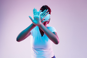 Image showing Young african-american woman\'s using VR-glasses in neon light