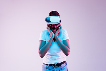 Image showing Young african-american woman\'s using VR-glasses in neon light