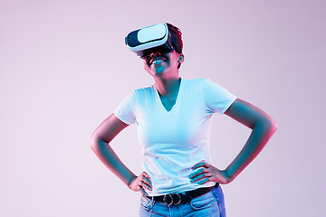 Image showing Young african-american woman\'s using VR-glasses in neon light