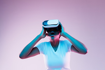 Image showing Young african-american woman\'s using VR-glasses in neon light