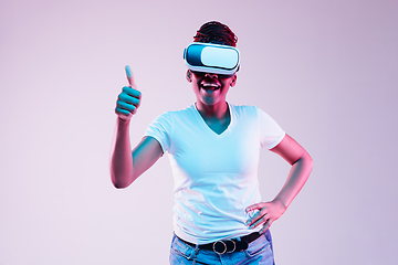 Image showing Young african-american woman\'s using VR-glasses in neon light