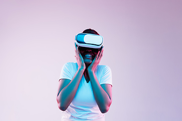 Image showing Young african-american woman\'s using VR-glasses in neon light