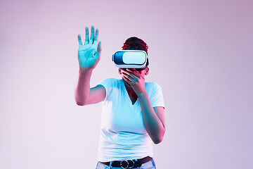 Image showing Young african-american woman\'s using VR-glasses in neon light